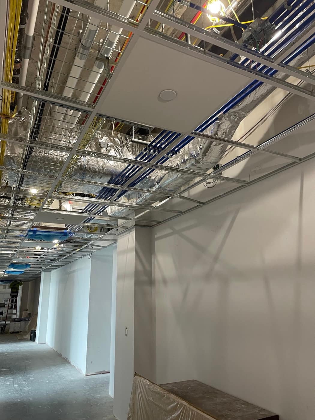 Wrapped duct in grid ceiling corridor