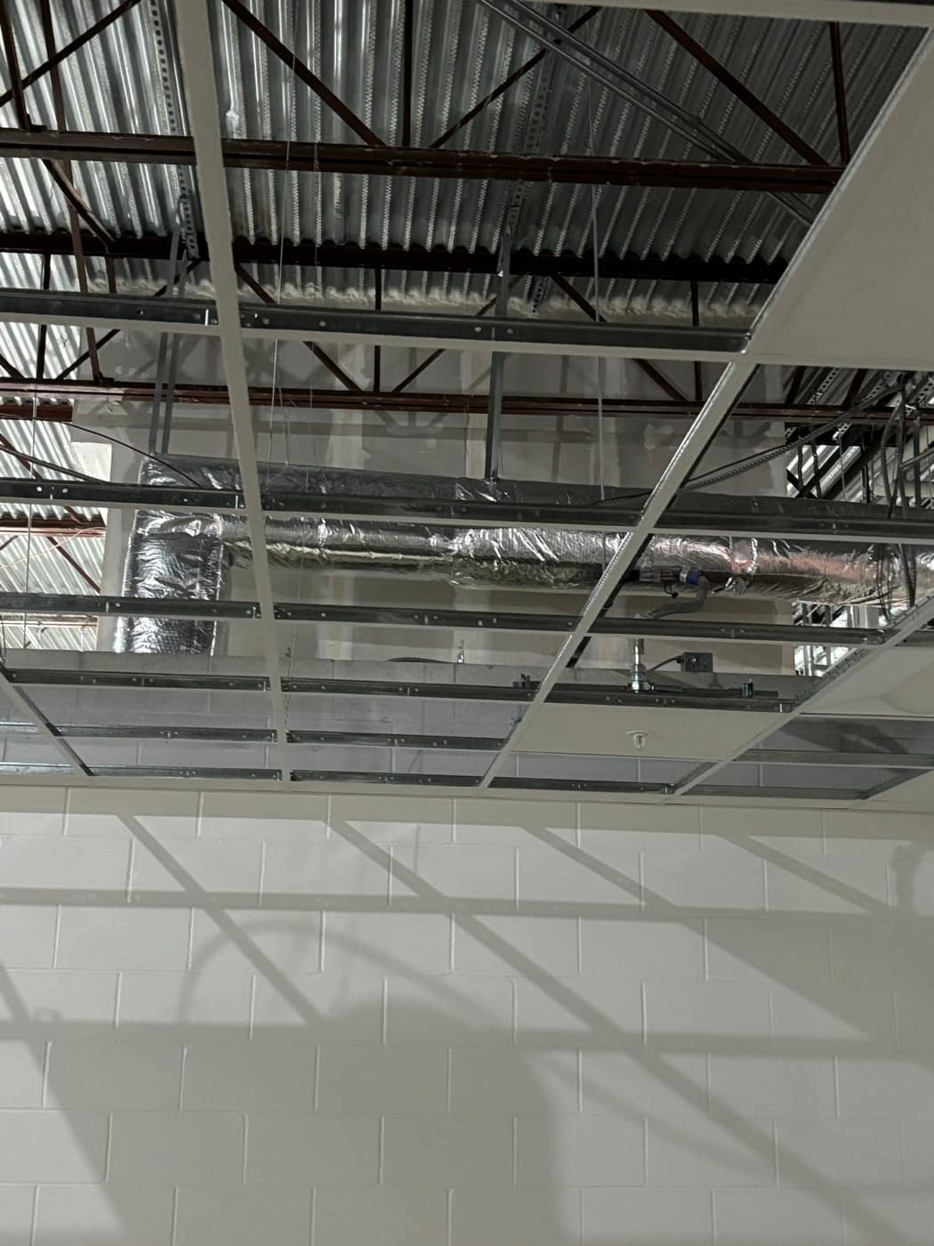 Foil wrapped duct above grid