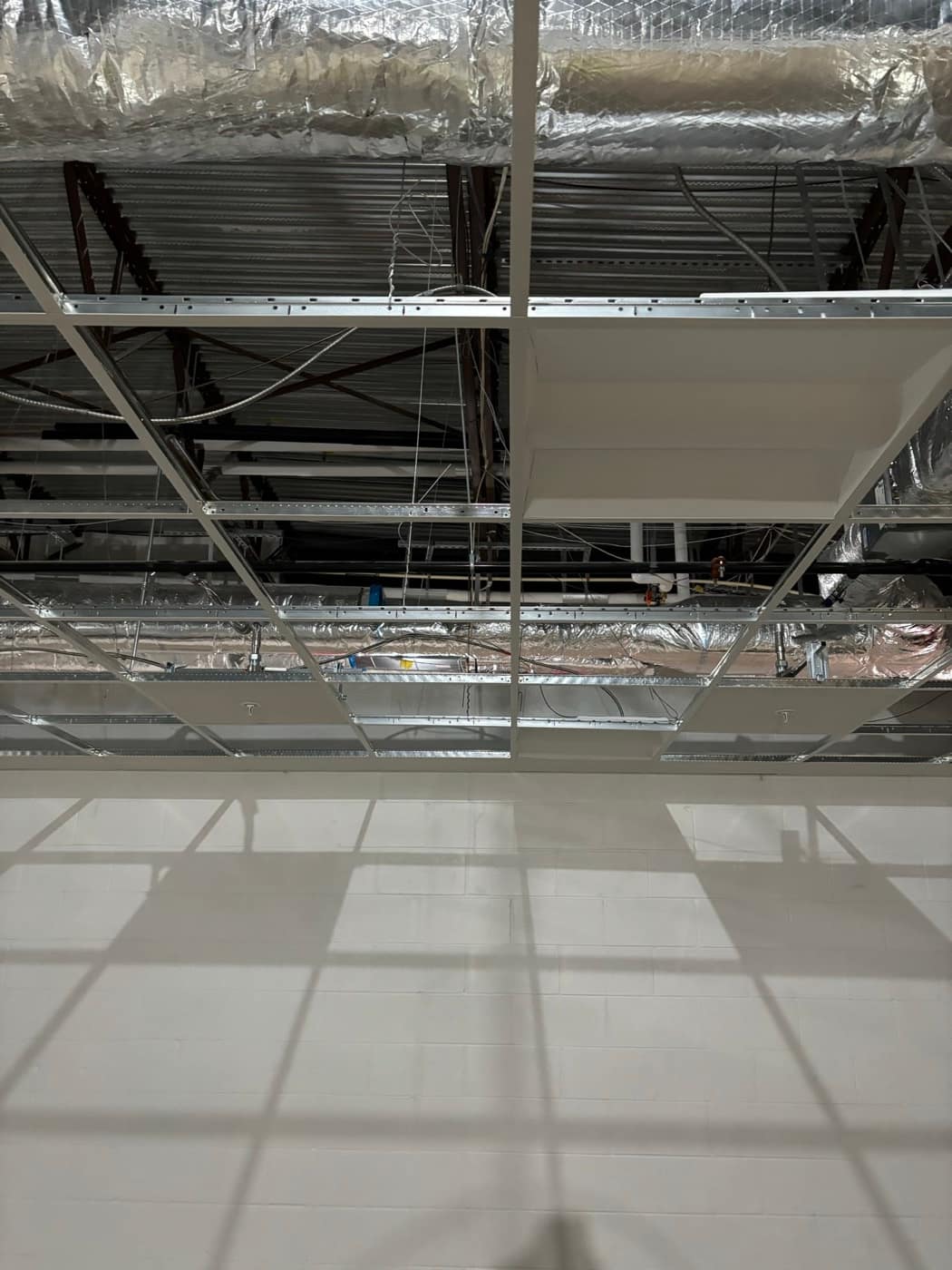 Ducts over open ceiling grid